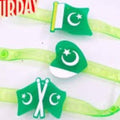 Three green plastic headbands with crescent and star designs, featuring one with the Pakistan flag and two with crossed crescent and star motifs, displayed on a white surface.